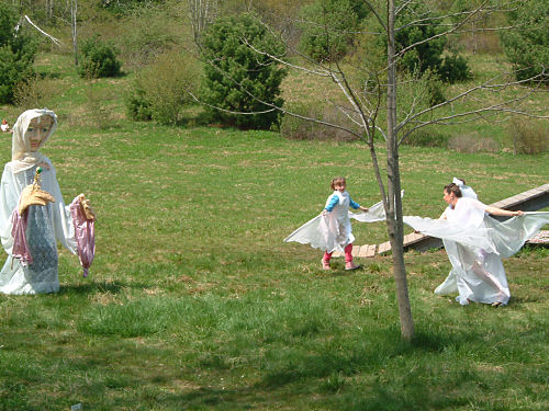 Giant puppet and wing-costumed dancers